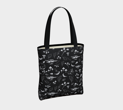Tote bag with nature themed print in white on a black background.