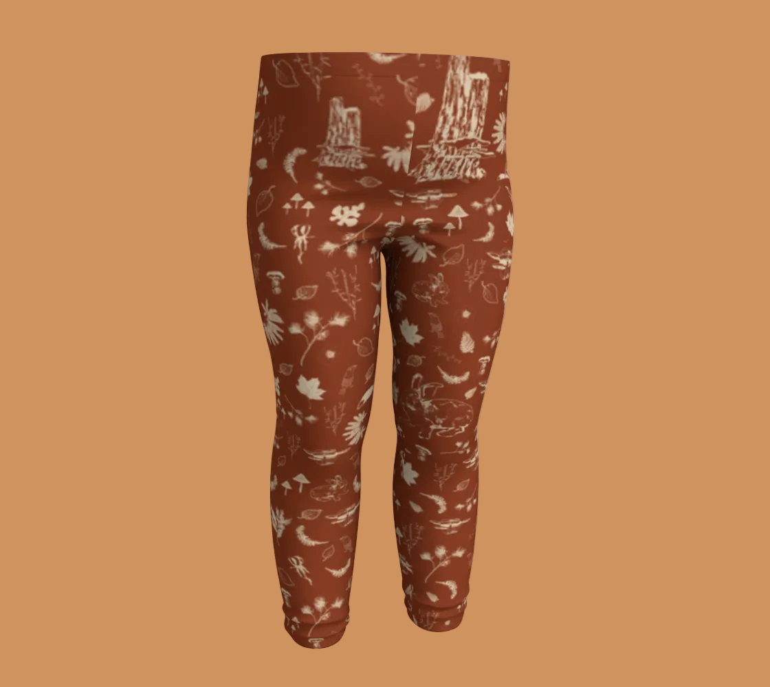 Orange baby leggings with light coloured forest motifs.