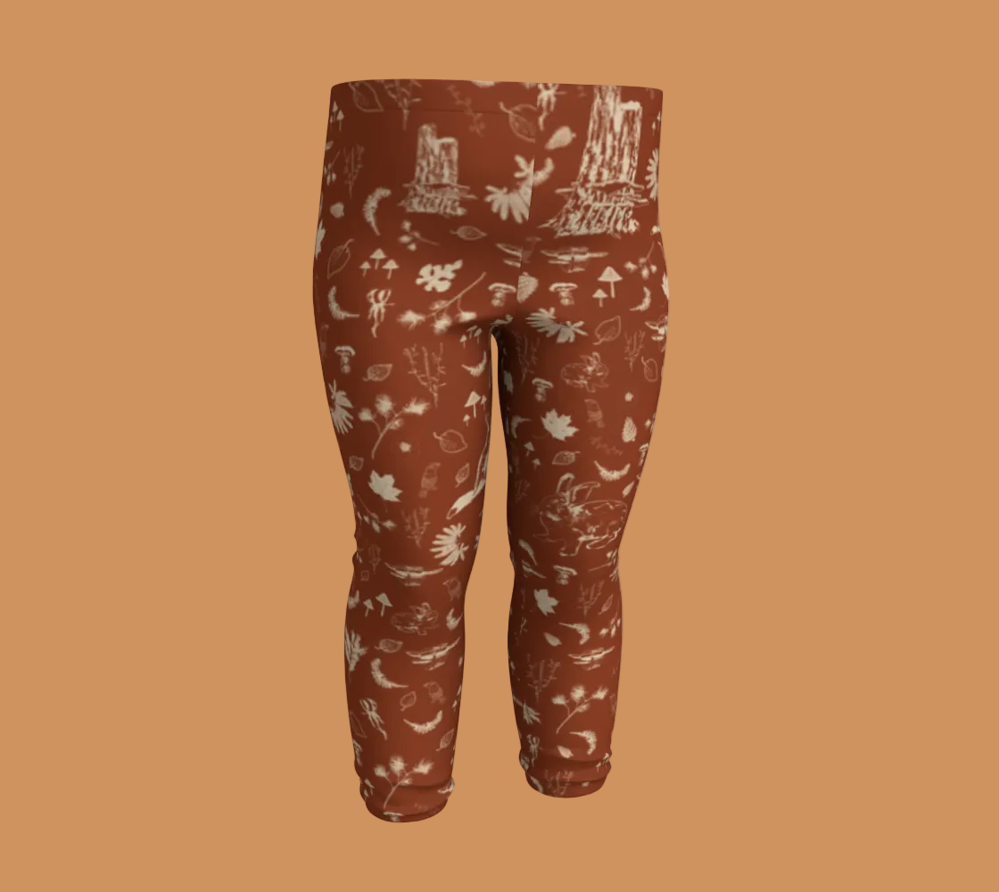 Orange baby leggings with light coloured forest motifs.